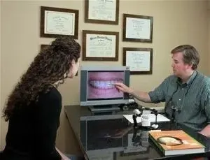Dr. Kinsley showing a patient an image of her teeth on the monitor.
